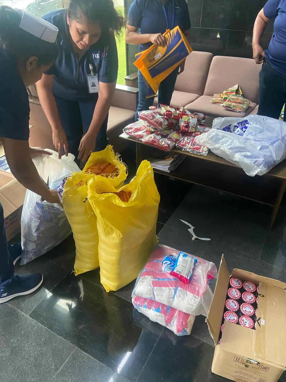 Image of a employees packing upplies donated by YKK Lanka for Flood relief