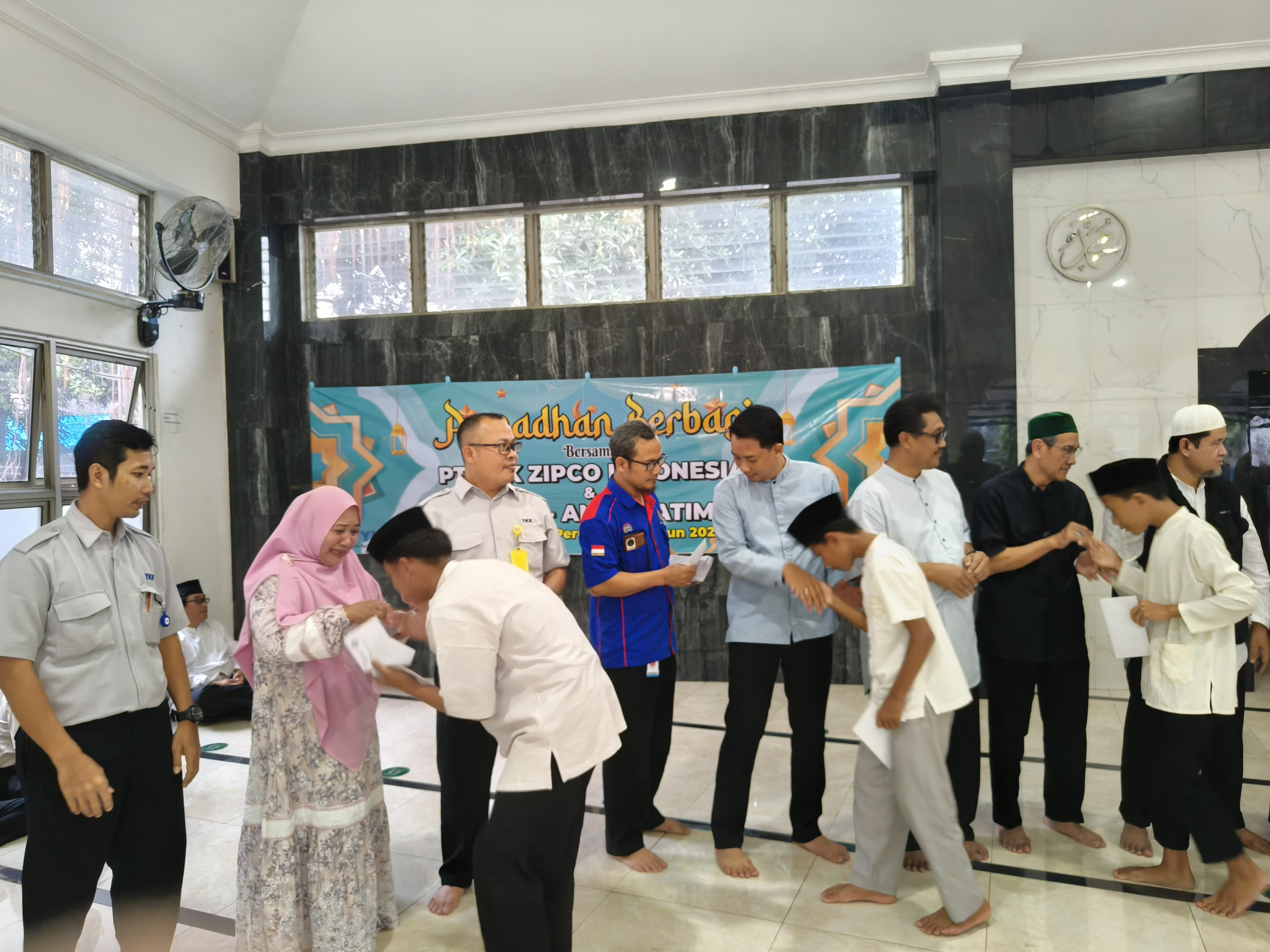 CSR 2 Saroto 2 group photo with members of YKK Zipco Indonesia shaking hands with orphans who attended the ramadan sharing